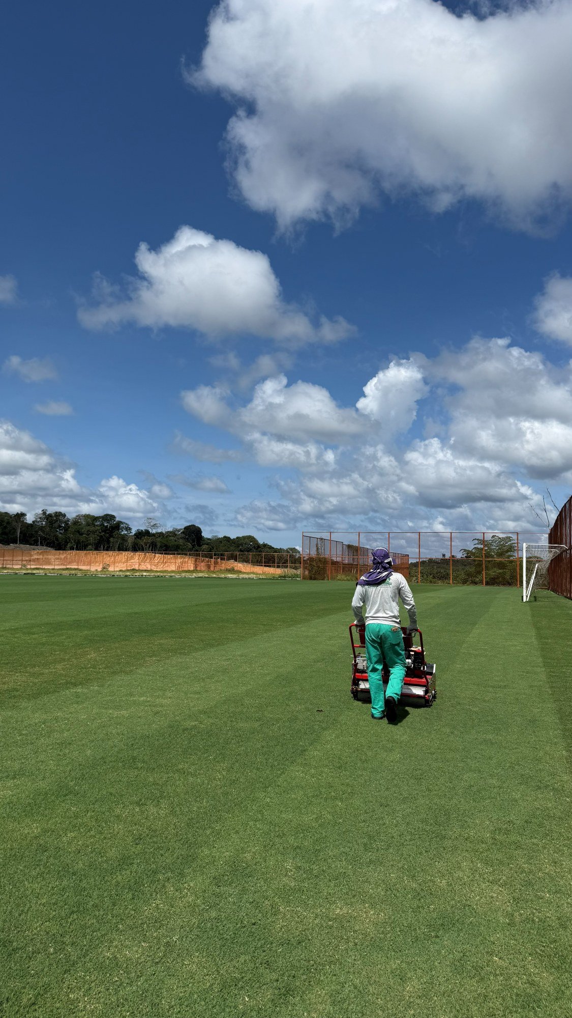 Equipe da Jiquitaia no corte do gramado do campo